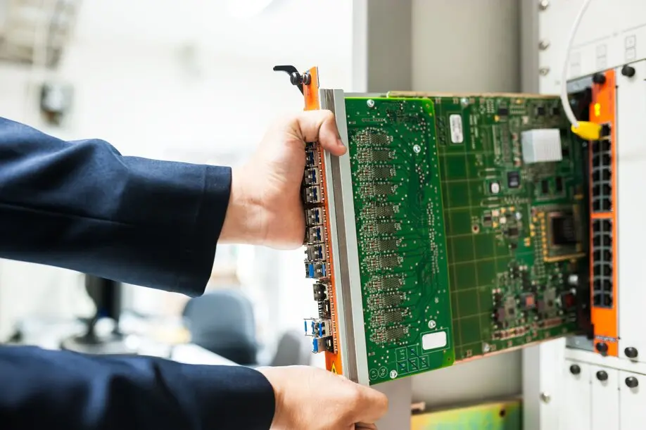 IT-Techniker arbeitet in einem Serverraum mit Racks und Netzwerkkomponenten